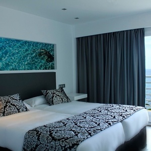 una habitación con una cama y una ventana con vista al océano