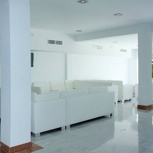 un hombre se sienta en un sofá frente a una computadora