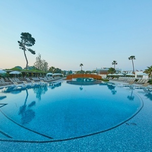 una gran piscina con sillas y sombrillas alrededor
