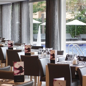 ein Restaurant mit vielen Tischen und Stühlen und einem Pool im Hintergrund