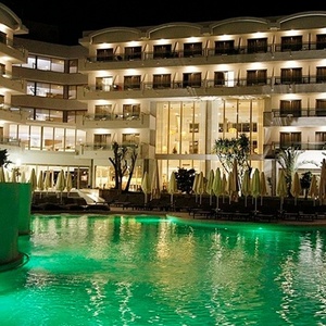a large hotel with a swimming pool in front of it