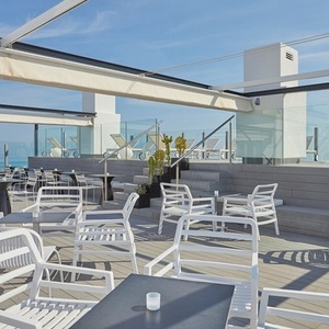 una terraza con mesas y sillas con vistas al océano