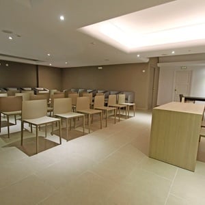 ein Raum mit vielen Stühlen und einem Tisch