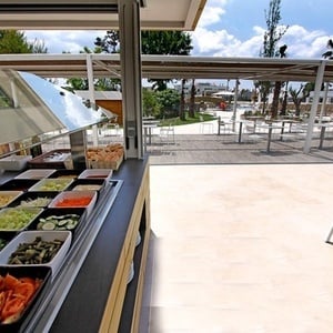 un mostrador de comida en un restaurante con varios platos de verduras