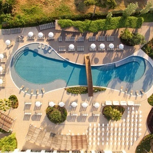 una vista aérea de una gran piscina rodeada de sillas y sombrillas