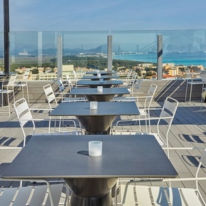 una terraza con mesas y sillas y una vista del océano