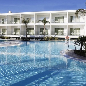 una piscina frente a un edificio de apartamentos blancos