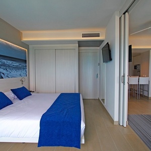 una habitación con una cama y una televisión en la pared