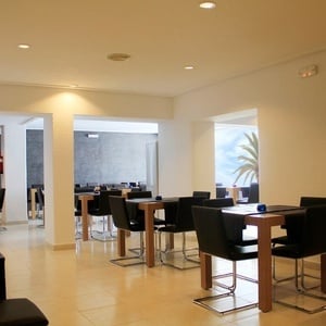 un restaurante con mesas y sillas negras y velas rosas