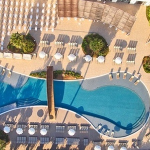 una vista aérea de una gran piscina rodeada de sillas y sombrillas