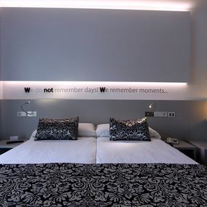 ein Hotelzimmer mit einem Bett und einem Aufkleber an der Wand , der sagt , wir erinnern uns an Momente