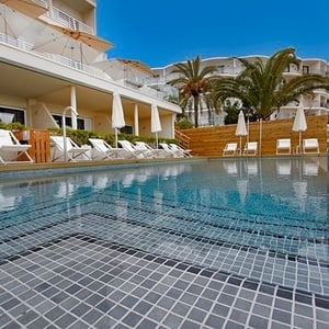 una piscina rodeada de sillas y sombrillas en un hotel
