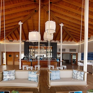 a restaurant with a bar and swings in the middle