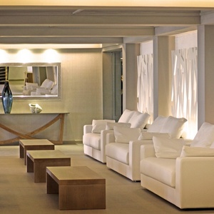 ein Wohnzimmer mit vielen weißen Möbeln und einem Spiegel