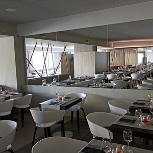 un restaurante lleno de mesas y sillas con copas de vino