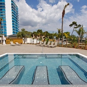 una piscina con sillas y un edificio en el fondo