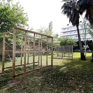a wooden structure in a grassy area with palm trees in the background