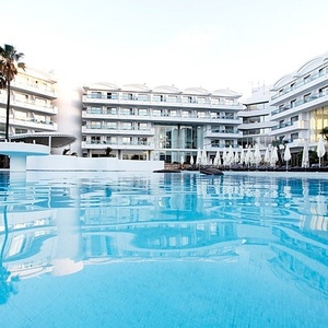 a large hotel with a large swimming pool in front of it