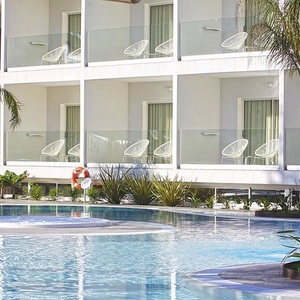 una piscina rodeada de balcones y sillas en un hotel