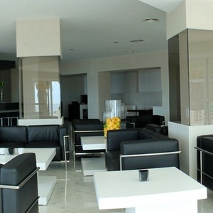 una sala de estar con sillas negras y mesas blancas