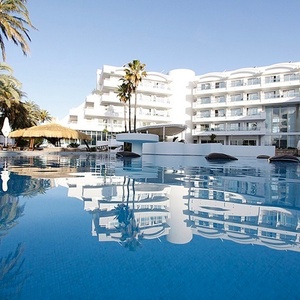 a large white building with a swimming pool in front of it