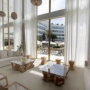a living room with white furniture and a large window