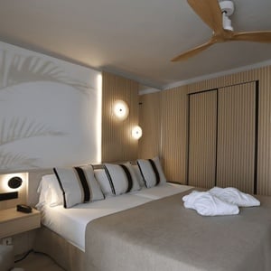 una habitación de hotel con mesita de noche y cama grande con luz led