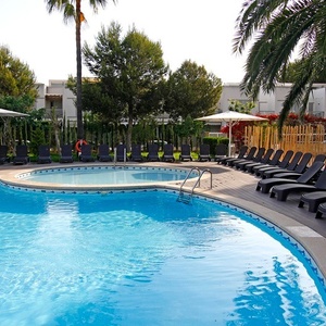 ein großer Swimmingpool mit Liegestühlen und Sonnenschirmen umgeben
