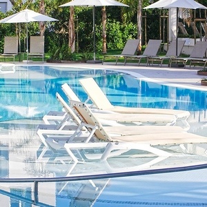 una piscina llena de sillas y sombrillas en un resort