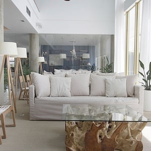 a living room with a white couch and a glass table