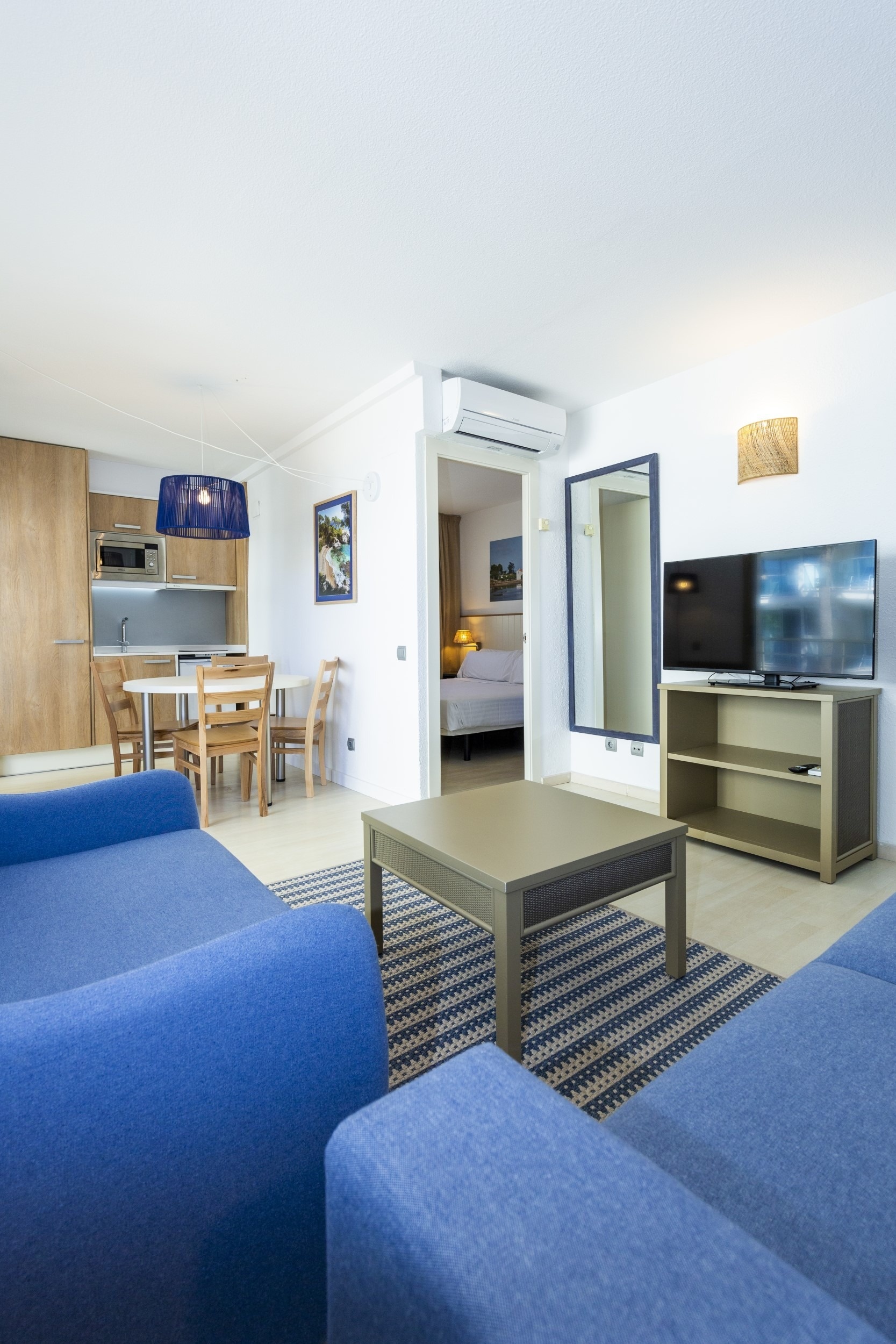 a living room with a blue couch a table and chairs