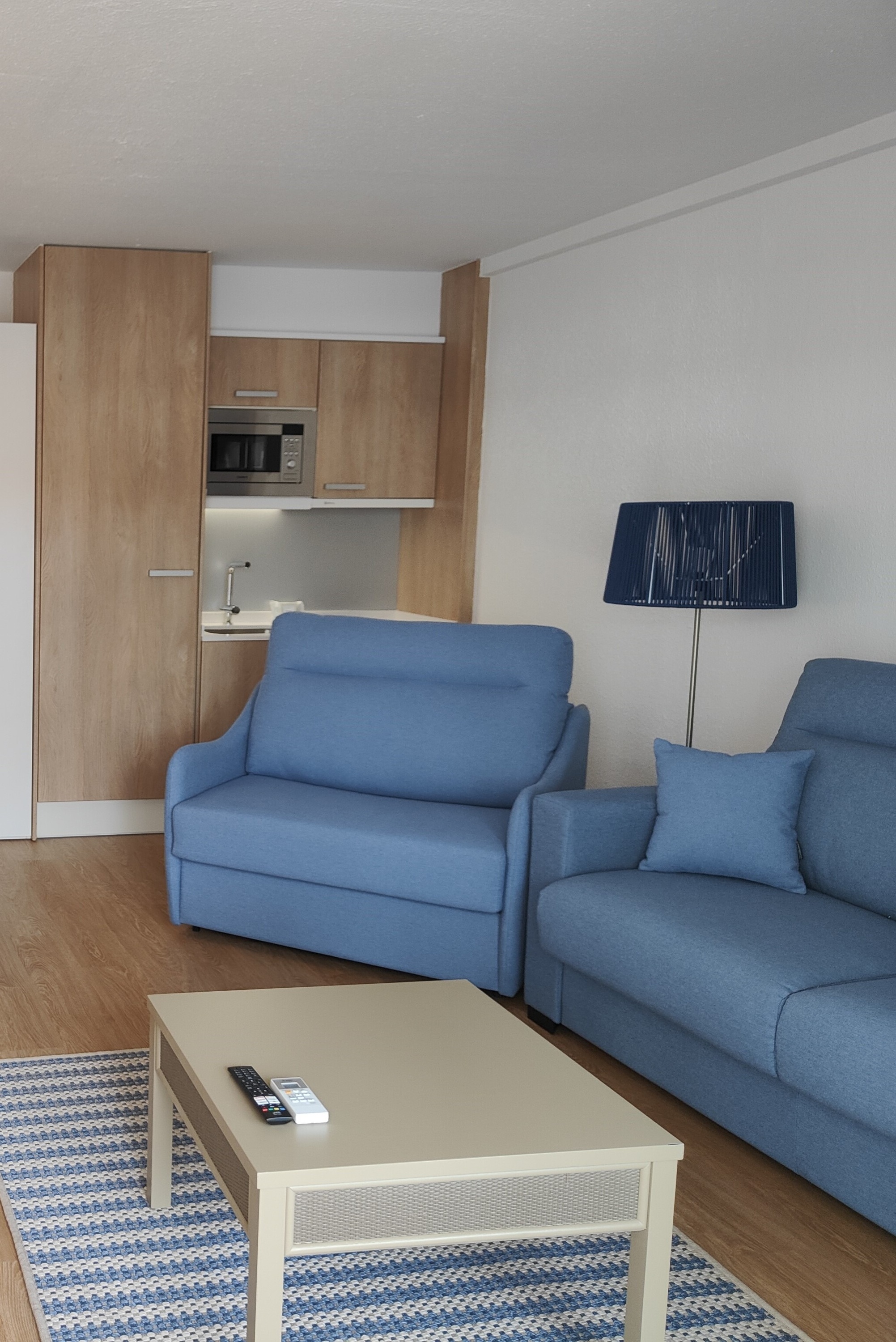 una sala de estar amb sofàs blaus i una mesa de centre