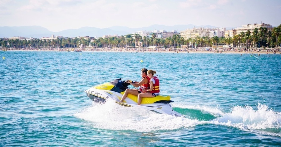 un hombre y una mujer montan un jet ski en el océano