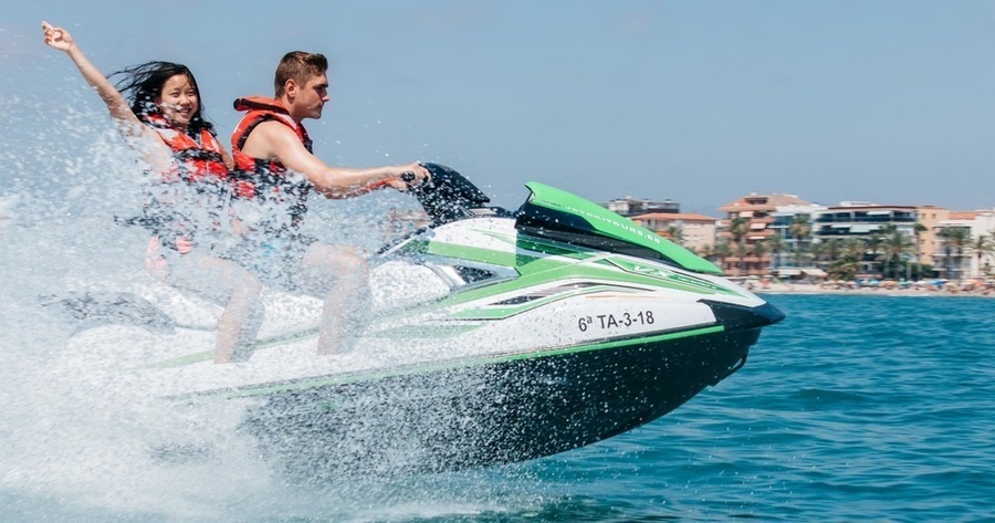 un hombre y una mujer conducen un jet ski en el océano
