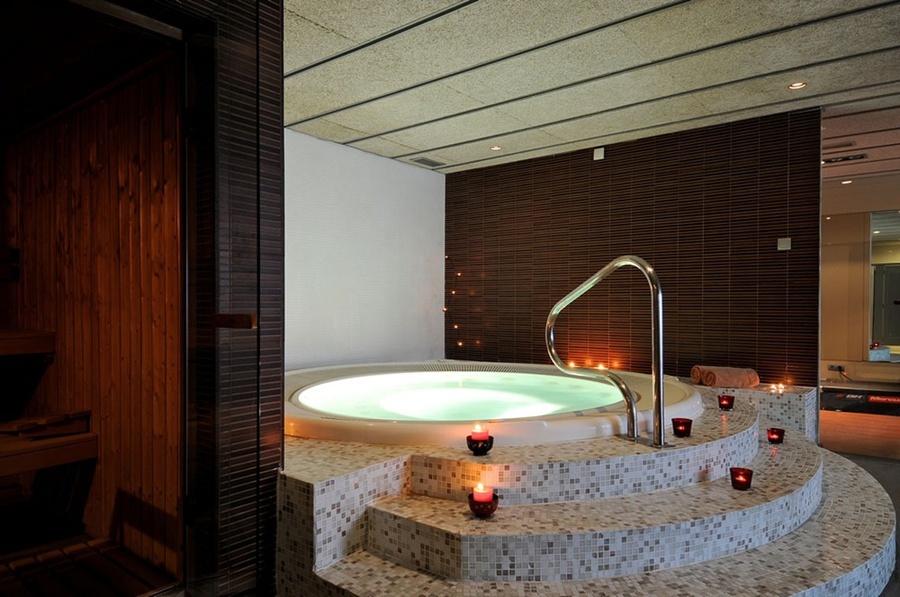 un jacuzzi rodeado de escaleras y velas en un spa