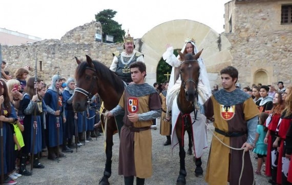 un grupo de personas vestidas con trajes medievales están montando caballos .