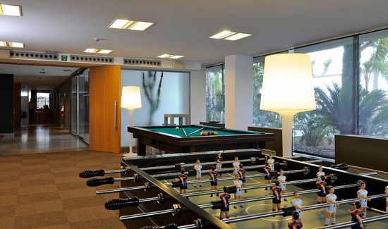 una sala de juegos con una mesa de billar y una mesa de fútbol