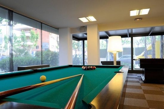 una mesa de billar en una habitación con muchas ventanas