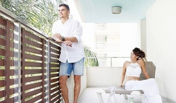 un homme et une femme se tiennent sur un balcon .