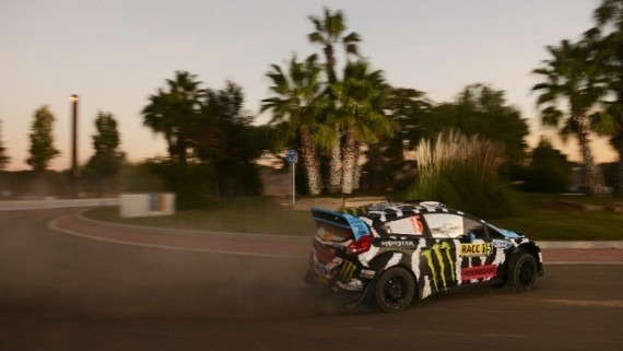 un coche de rally está conduciendo por una carretera rodeada de palmeras .