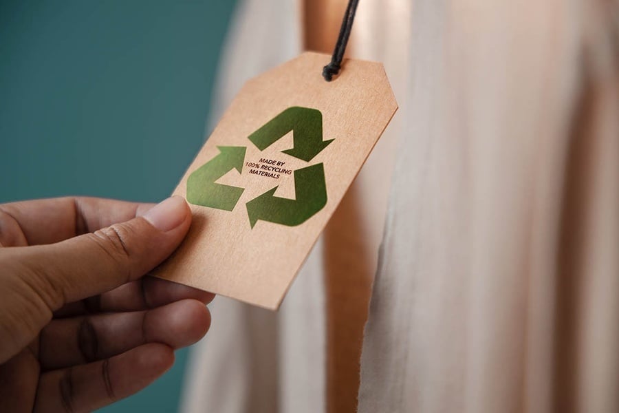 une personne tient une étiquette avec un symbole de recyclage sur elle