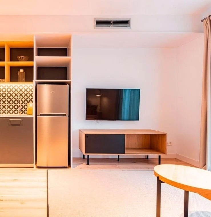 a kitchen with a stainless steel refrigerator and a flat screen tv