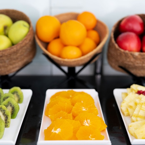 Fresh fruit platter with kiwi, oranges, and pineapple, perfect for a Bohemian Hotels breakfast.