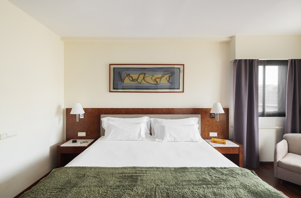 Comfortable Bohemian Hotels room with a plush bed, modern art, and bedside lamps.