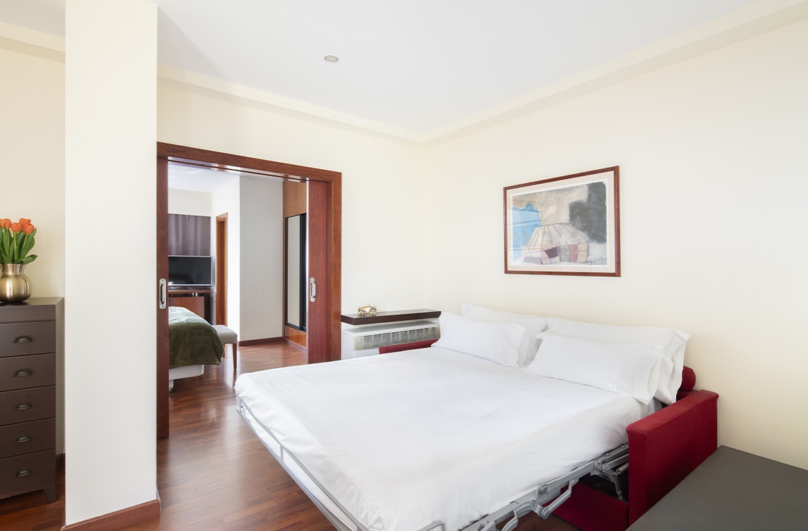 Spacious suite at Bohemian Hotels with comfortable bed and modern amenities.