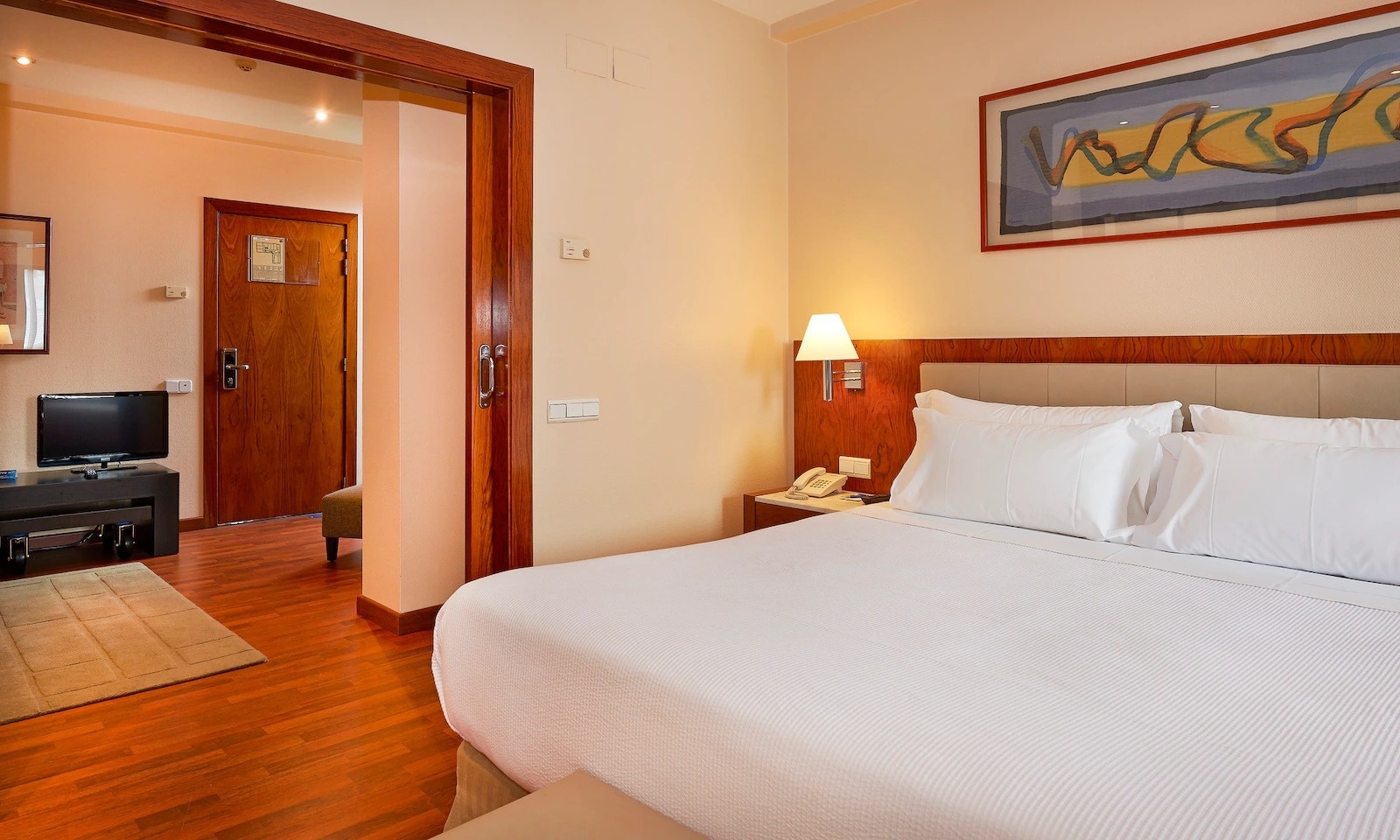 una habitación de hotel con dos camas , un escritorio y una televisión