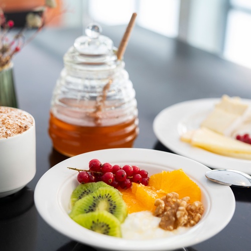 Breakfast at a Bohemian Hotel: coffee, fruit bowl, cheese, and honey.