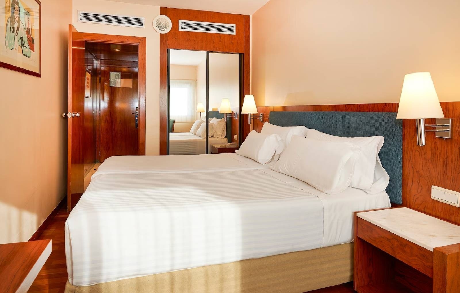 una habitación de hotel con dos camas y un lavabo