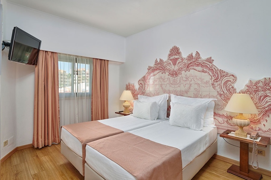 um quarto de hotel com duas camas e uma televisão