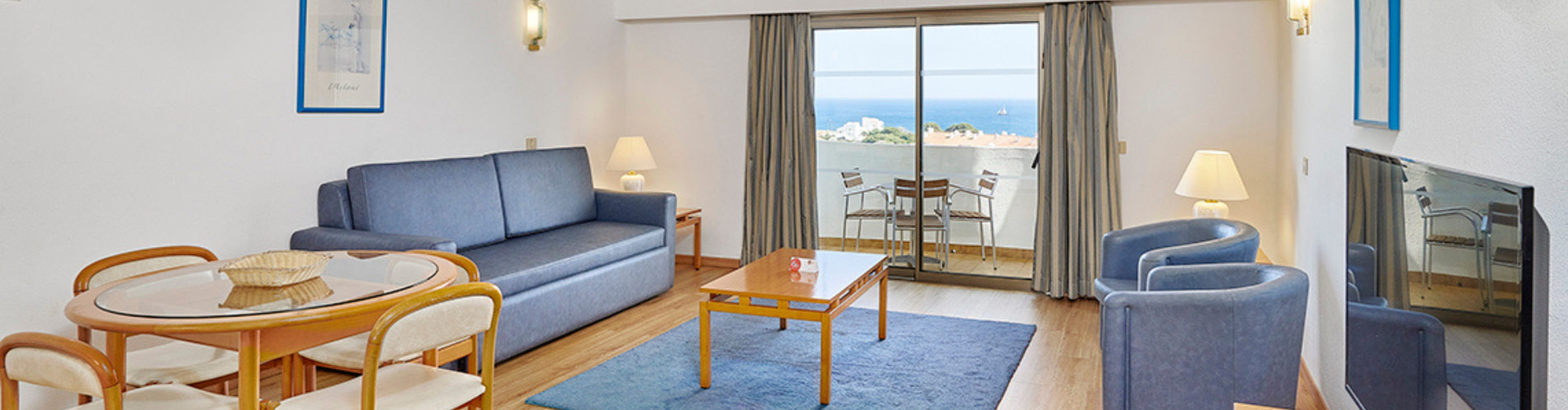 uma sala de estar com um sofá azul e uma mesa de jantar